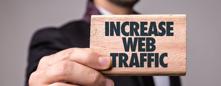 Man holding a wood brick saying "Increase Web Traffic"
