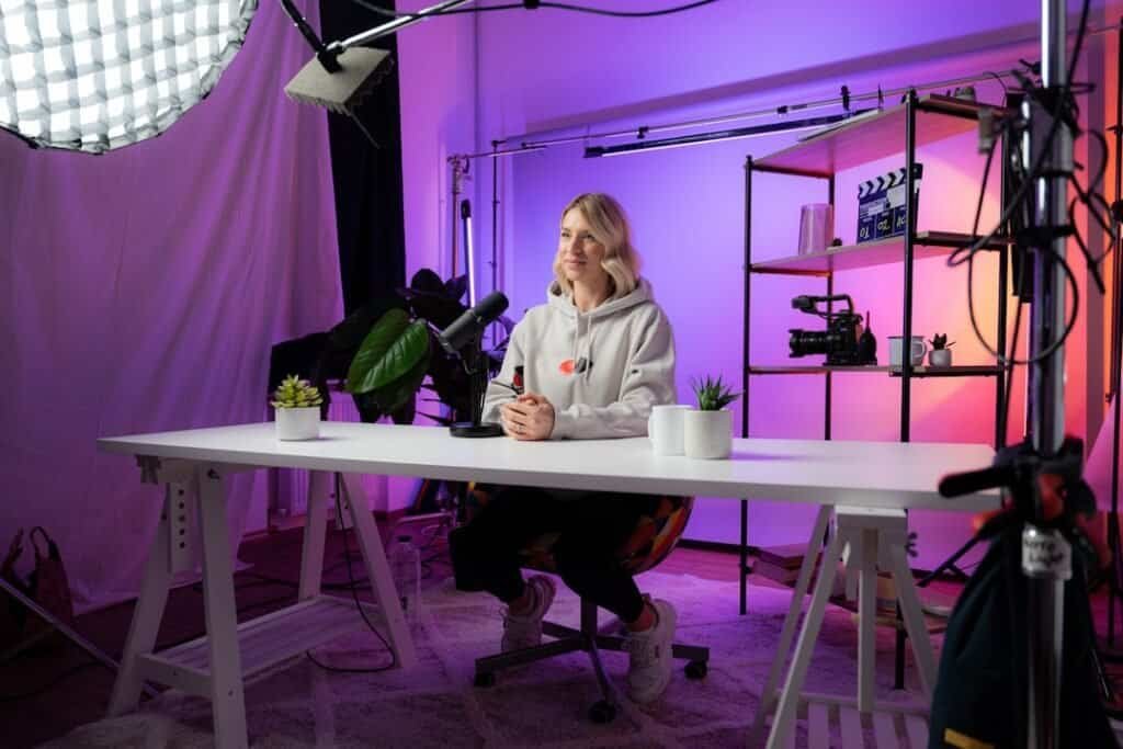 a woman sitting at a table in front of a camera video marketing